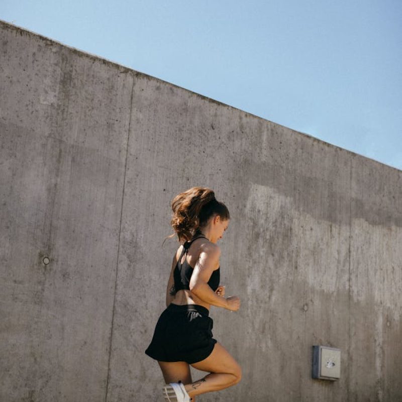pexels-photo-8520628 Woman in Black Tank Top and Black Shorts Running on Concrete Steps